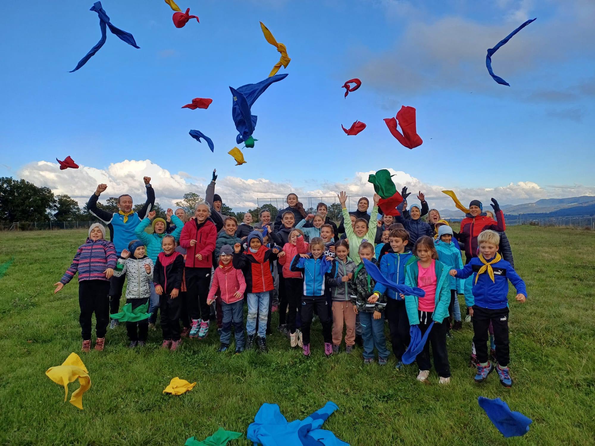 Enfants, jeunes et entraîneurs du CA Fontenais lançant des foulards colorés en l'air